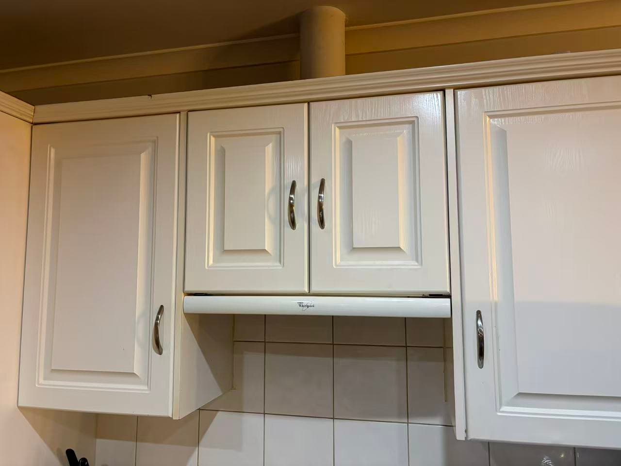 Aligned white kitchen cabinet doors after Mel One adjustment work