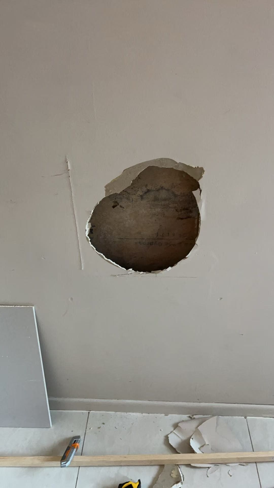 Existing opening in an interior plasterboard wall before the recorded repair